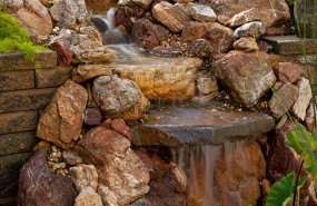 Pond Magic - Saratoga Pondless Waterfall with Stream and Landscaping, set in a patio built with pavers.